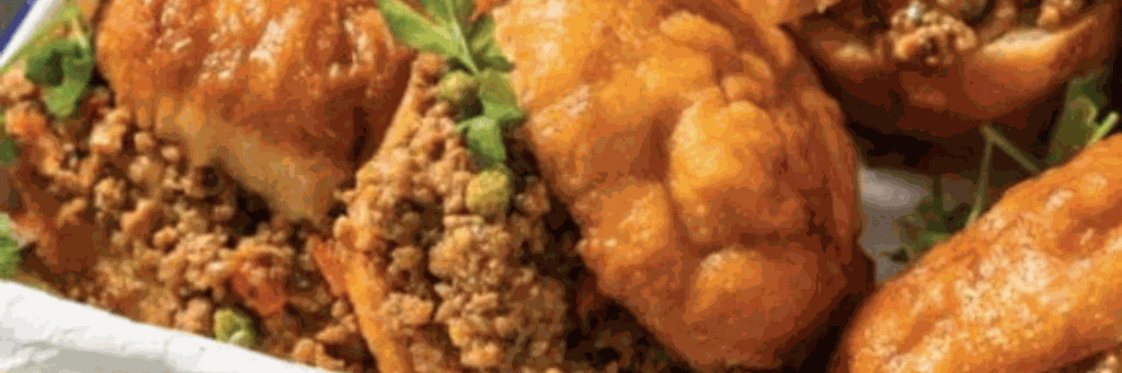 Golden fried vetkoek bread balls on a white plate