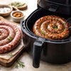 Golden-brown boerewors sausage coil cooking evenly in an air fryer basket