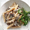 Biltong Potjie cooking with onions mushrooms green peppers tomato sauce pasta and cheese in potjie pot
