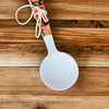 Enamel printed sugar spoon with black floral design and wooden handle