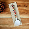 Enamel printed sugar spoon with black floral design and wooden handle