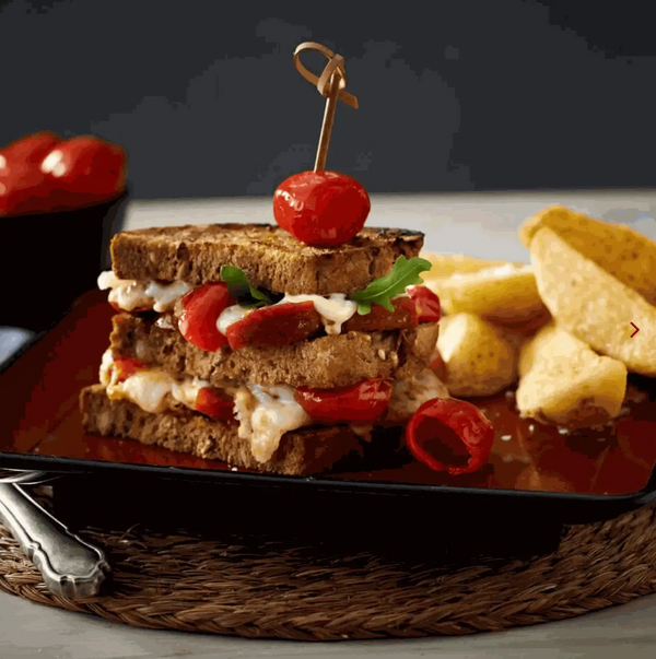 PEPPADEWS Mild whole peppers in sandwich with cheese and chips on plate